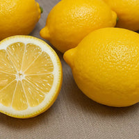 Thumbnail for Three Eureka lemons, one of which is cut in half, Fruit Trees sold by Paradise Nursery.